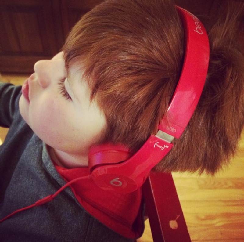 A child listening to music through red headphones — visit the Fintasta blog